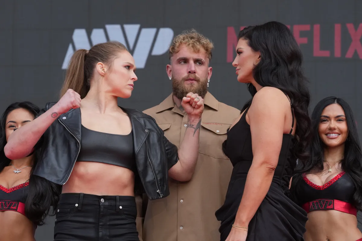 Mar 10, 2026; Inglewood, California, United States; Ronda Rousey (left) and Gina Carano (right) face off as Jake Paul (center) watches at a press conference for their upcoming MMA featherweight bout at Intuit Dome. Mandatory Credit: Kirby Lee-Imagn Images