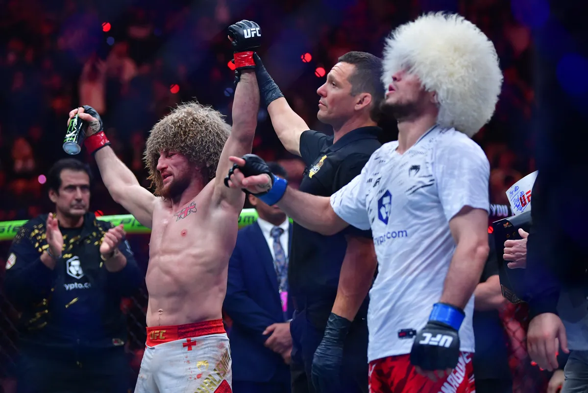 Jan 18, 2025; Inglewood, California, USA; Merab Dvalishvili (red gloves) celebrates after winning a UFC bantamweight title fight against Umar Nurmagomedov (blue gloves) during UFC 311 at Intuit Dome. Mandatory Credit: Gary A. Vasquez-Imagn Images