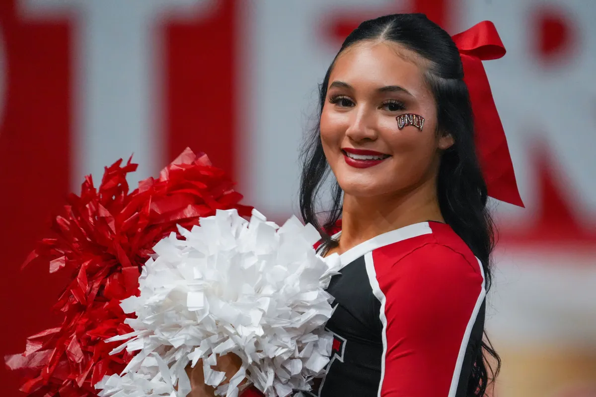 Dec 23, 2025; Frisco, TX, USA; A UNLV Rebels cheerleader shows her spirit during the second half of a game against the Ohio Bobcats at the Ford Center at The Star. Mandatory Credit: Raymond Carlin III-Imagn Images